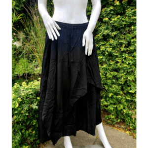 A mannequin wearing black clothing and standing on the sidewalk.