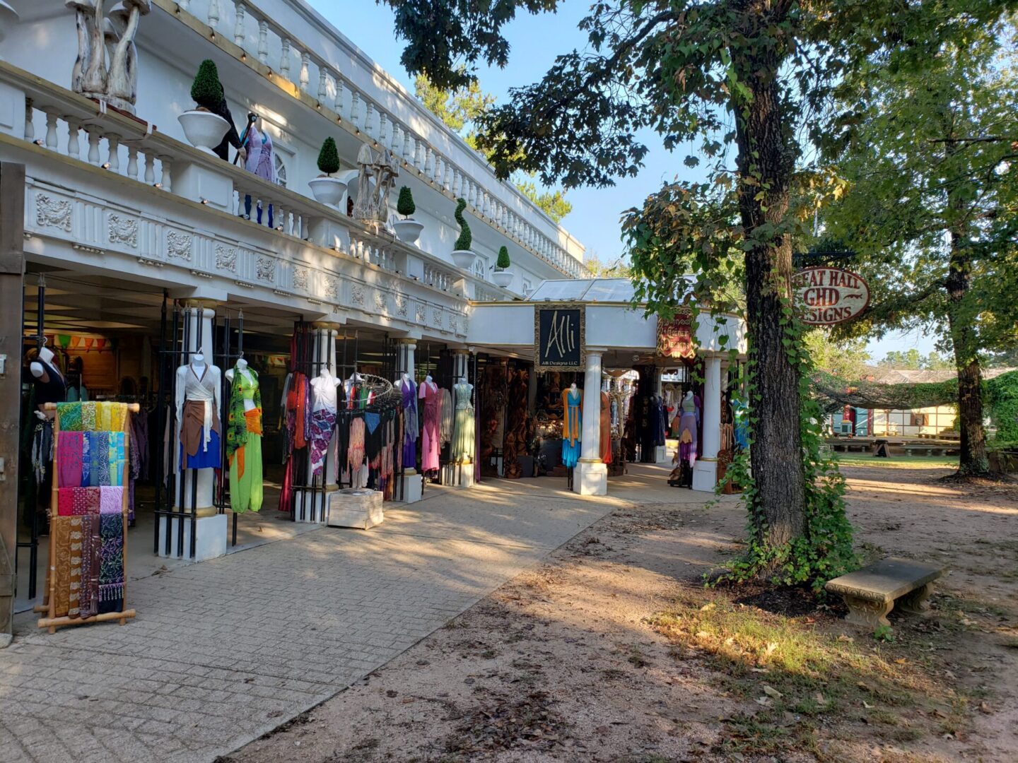 A street scene of a store front with many items on display.