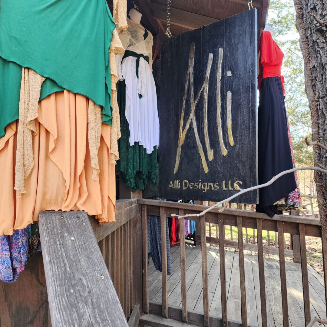 A sign that says ali designs llc hanging from the side of a building.